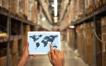 Person using a touchpad to ship orders in a large warehouse