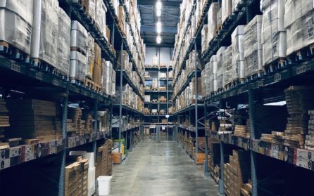 Warehouse aisle with towering shelves full of packages